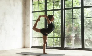 young-attractive-woman-natarajasana-pose-studio-background (1)_Activ Living Community