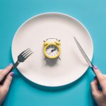 hands-holding-knife-fork-alarm-clock-plate-blue-background f_Activ Living Community