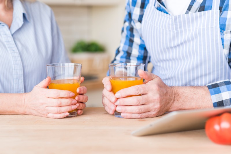 close-up-senior-couple-holding-glass-juice-wooden-table (1)_Activ Living Community