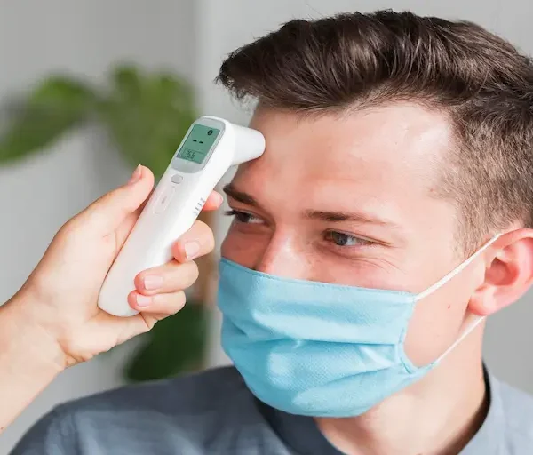 man-with-medical-mask-checking-temperature-office-with-thermometer_Activ Living Community